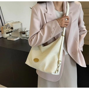 Détail du sac demi-lune blanc en cuir PU souple avec logo métallique doré