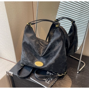 Gros plan d'un sac cabas noir rétro avec boucles dorées et cuir mat texturé élégant