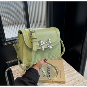 Detail van de avocado groene leren crossbodytas met een zilveren metalen strikgesp