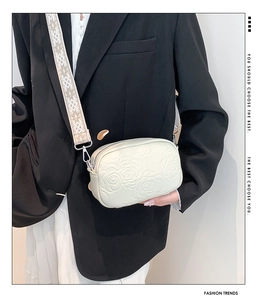 Detail of cream mini crossbody bag with embossed rose pattern and jacquard strap