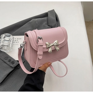 Roze mat lederen crossbody tas met een zilveren metalen strikgesp als detail