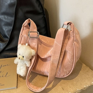 Bolso bandolera rosa con textura plisada y un lindo colgante de osito de peluche blanco