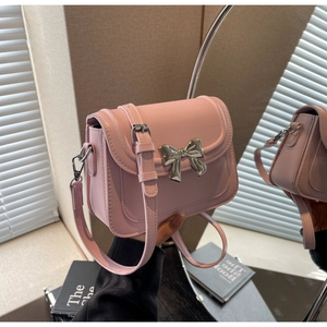 Detail van roze crossbodytas met zilveren strikgesp en verstelbare riem