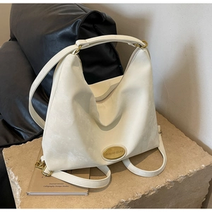 Détail d'un sac hobo crème minimaliste avec boucle en métal vintage sur socle
