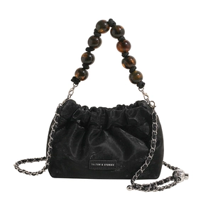 Black velvet drawstring bucket bag featuring amber bead handle and silver chain strap
