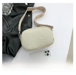 Detail of off-white PU leather crossbody bag with rose relief and jacquard strap