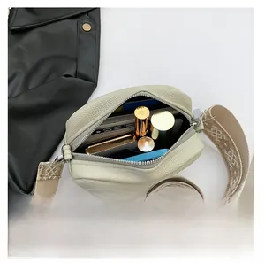 Internal view of cream square bag showing capacity for phone and lipstick with wide strap
