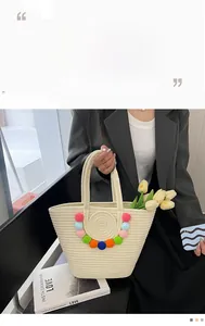 Detailed close-up of woven tote bag with colorful pom-poms for beach vacation style