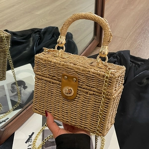 Handmade straw box bag with chain strap and leather lock detail for summer beach vacations