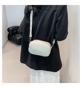 Detail of beige PU leather crossbody bag with rose embossing and jacquard strap