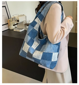 Detail view of multi-tone blue denim patchwork tote bag on shoulder for daily styling