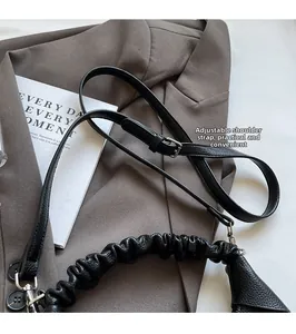 Detail of lychee pattern leather bag with adjustable strap and silver metal hardware