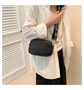 Close-up of black PU leather crossbody bag featuring 3D rose floral embossed details