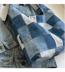 Detailed view of patchwork denim tote bag with textured blue fabric squares and side label