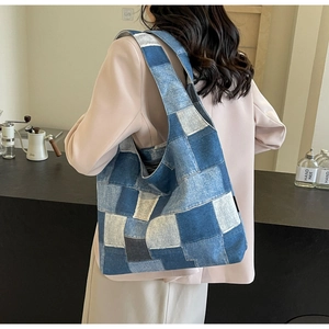 Detailed view of a handmade patchwork denim tote bag worn by a model in casual style