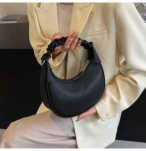 Detail of the black lychee pattern leather crescent bag with unique scrunchie handle