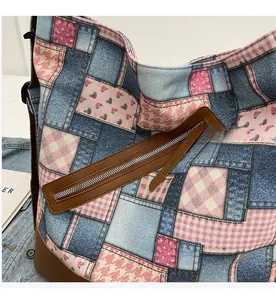 Detailed view of patchwork canvas tote bag featuring floral patterns and smooth metal zipper