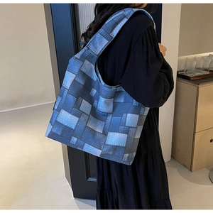 Close-up of large blue canvas tote bag with vintage denim patchwork print for casual wear