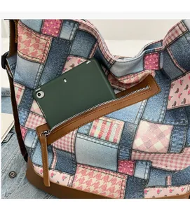 Detail of a patchwork canvas tote featuring a side zipper pocket holding a green tablet