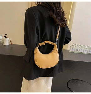 Chic yellow dumpling bag with ruched handle and pebbled leather texture detail