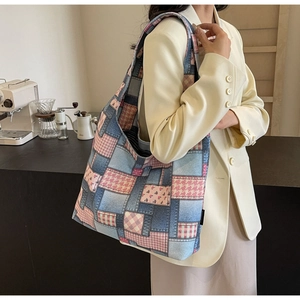 Close-up of patchwork canvas tote bag with denim and floral patterns worn by a model