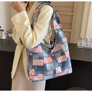 Close-up of patchwork tote bag featuring blue denim, pink plaid, and floral patterns