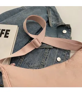 Detail of adjustable wide shoulder strap and plastic buckle on pink canvas bag