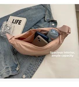 Spacious pink half-moon bag interior showing capacity for phones and an umbrella