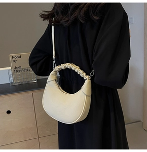 Detail of off-white dumpling bag with scrunchie handle and lychee leather texture