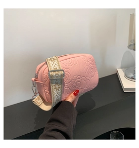 Detail of pink crossbody bag with camellia embossing and patterned jacquard strap