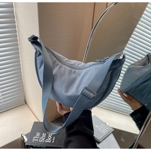 Detail view of the Morandi blue crescent bag with wide adjustable strap in mirrors