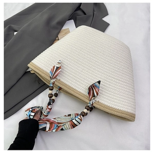 Detail of woven tote bag with silk scarf handle and dark wooden beads detail