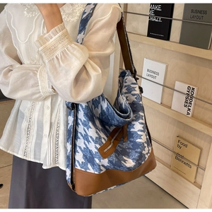 Detail of blue houndstooth tote with brown leather strap and side zipper pocket