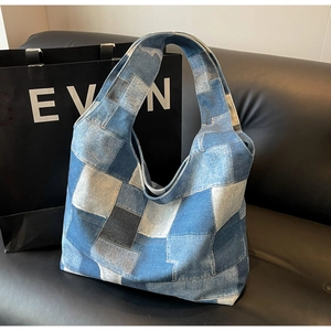 Close-up of vintage patchwork denim tote bag showing multi-tone blue fabric texture
