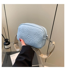 Detail of light blue embossed rose pattern on lychee grain PU leather bag with floral strap