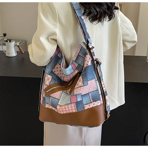 Detail of vintage patchwork canvas tote with floral patterns and brown leather base
