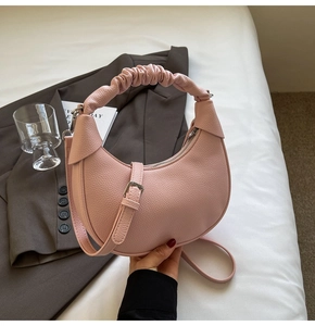 Detail of pink lychee texture leather hobo bag with unique pleated handle and slim strap