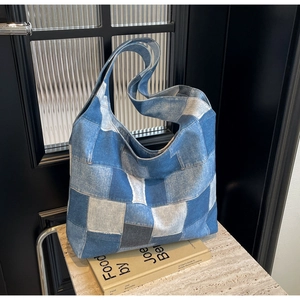 Detail shot of the large denim patchwork tote bag on a book with soft natural lighting