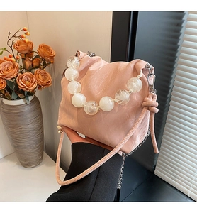 Detailed shot of pink pleated bucket bag with large translucent beaded handle and drawstring