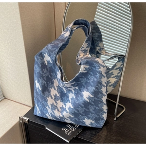 Close-up of blue houndstooth tote bag on a wooden counter with minimalist decor