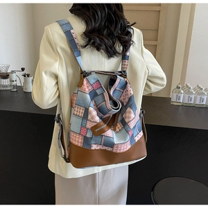 Detail of colorful patchwork tote bag with denim and leather base on a model back