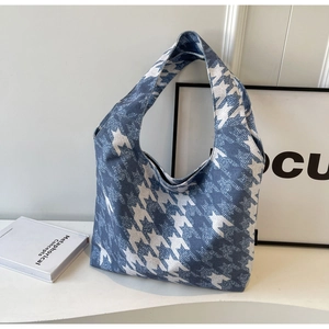Detailed close-up of blue and white houndstooth canvas tote bag in a minimalist setting