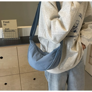 Detail of blue crescent crossbody bag made of durable canvas with adjustable wide strap