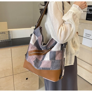 Side view of large color-block canvas tote bag with brown leather straps and metal zipper