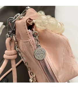Macro shot of pink pleated bucket bag with transparent beaded handle and silver zipper detail