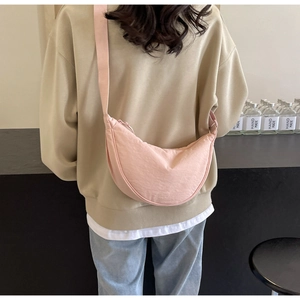 Back view of a large pink crescent crossbody bag showing its capacity and nylon texture