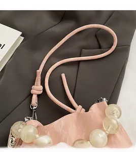 Detail of pink suede bucket bag with large translucent beaded handle and silver clasps