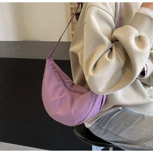 Detail of lavender nylon crescent bag featuring waterproof fabric and wide shoulder strap