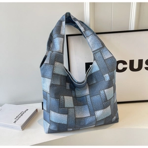 Detail of blue denim patchwork print canvas tote bag with seamless shoulder strap design
