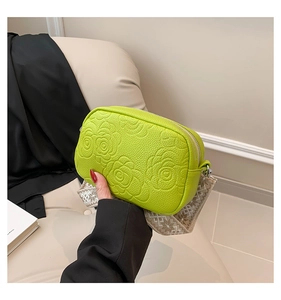 Macro view of bright green lime crossbody bag with 3D rose floral embossed texture